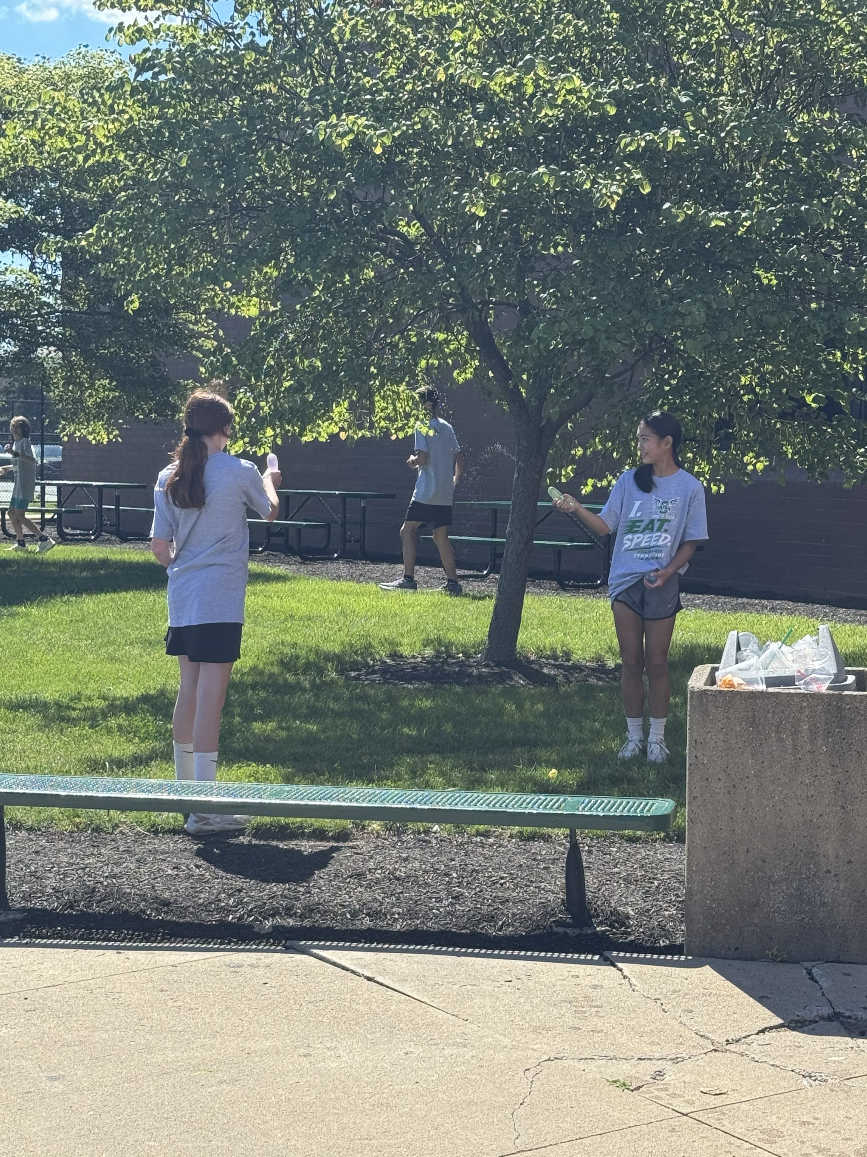 Girls playing catch with water balloons outside