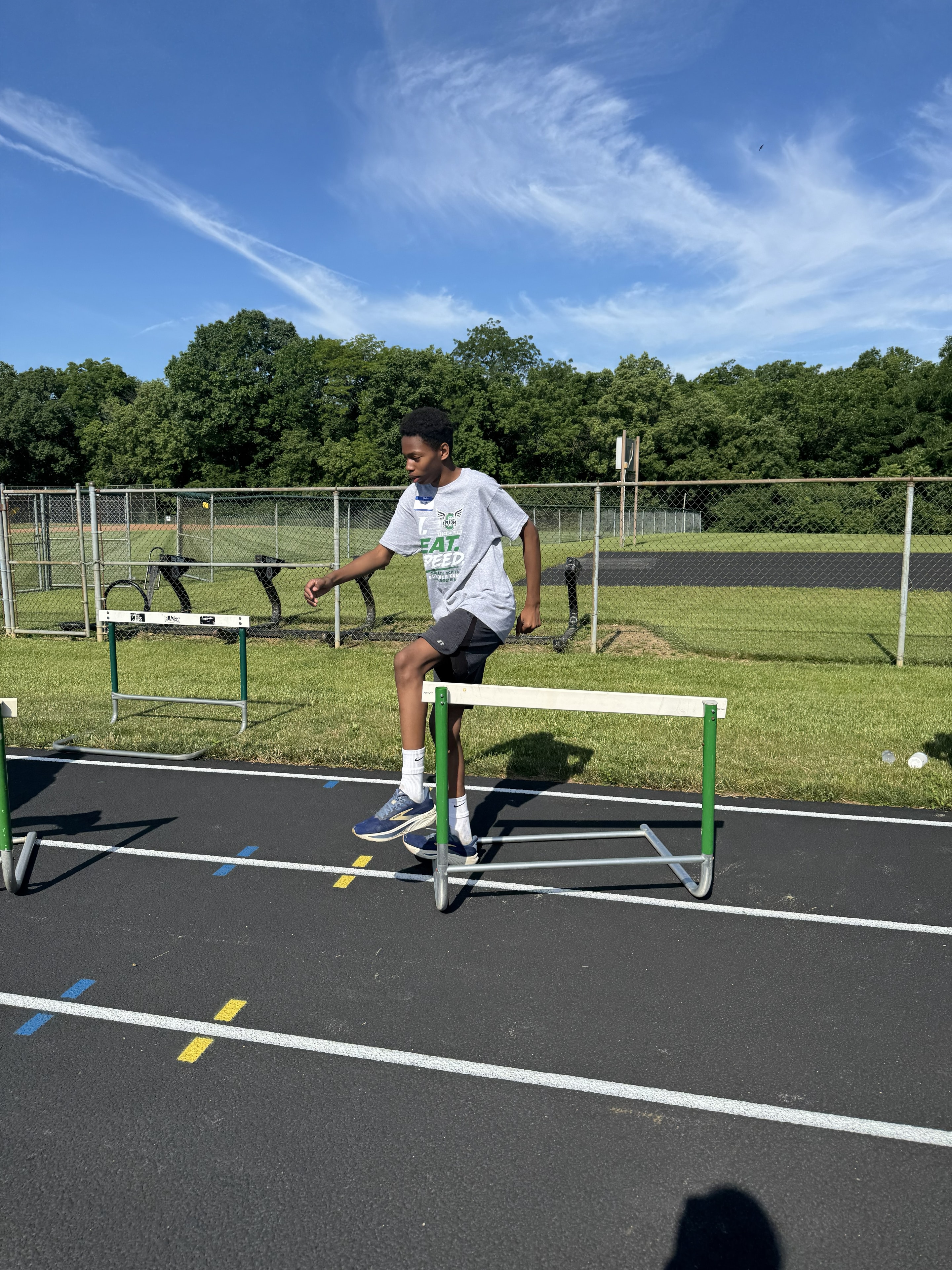 Camper stepping over a hurdle during drills