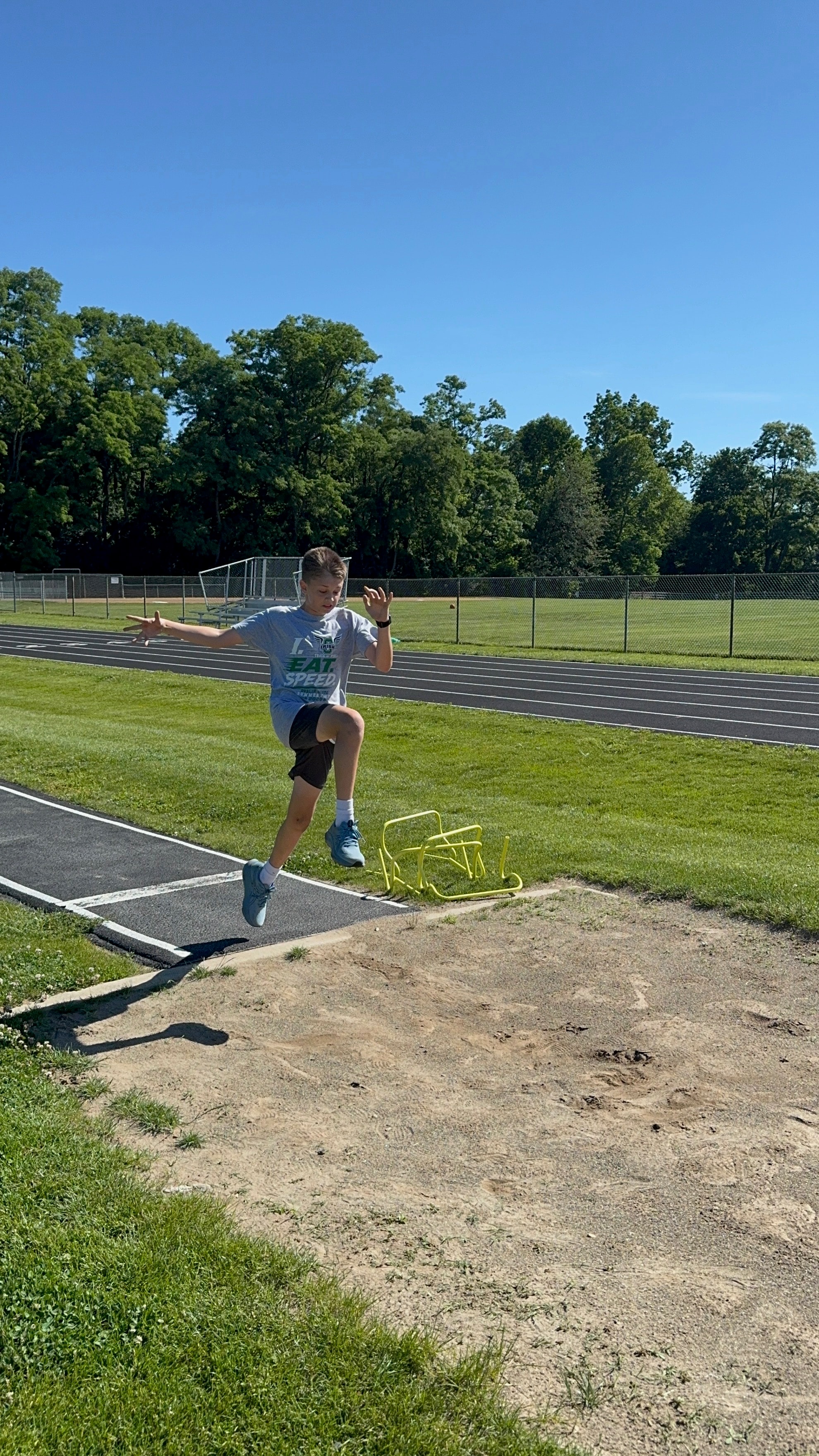 Young athlete launching into the long jump pit