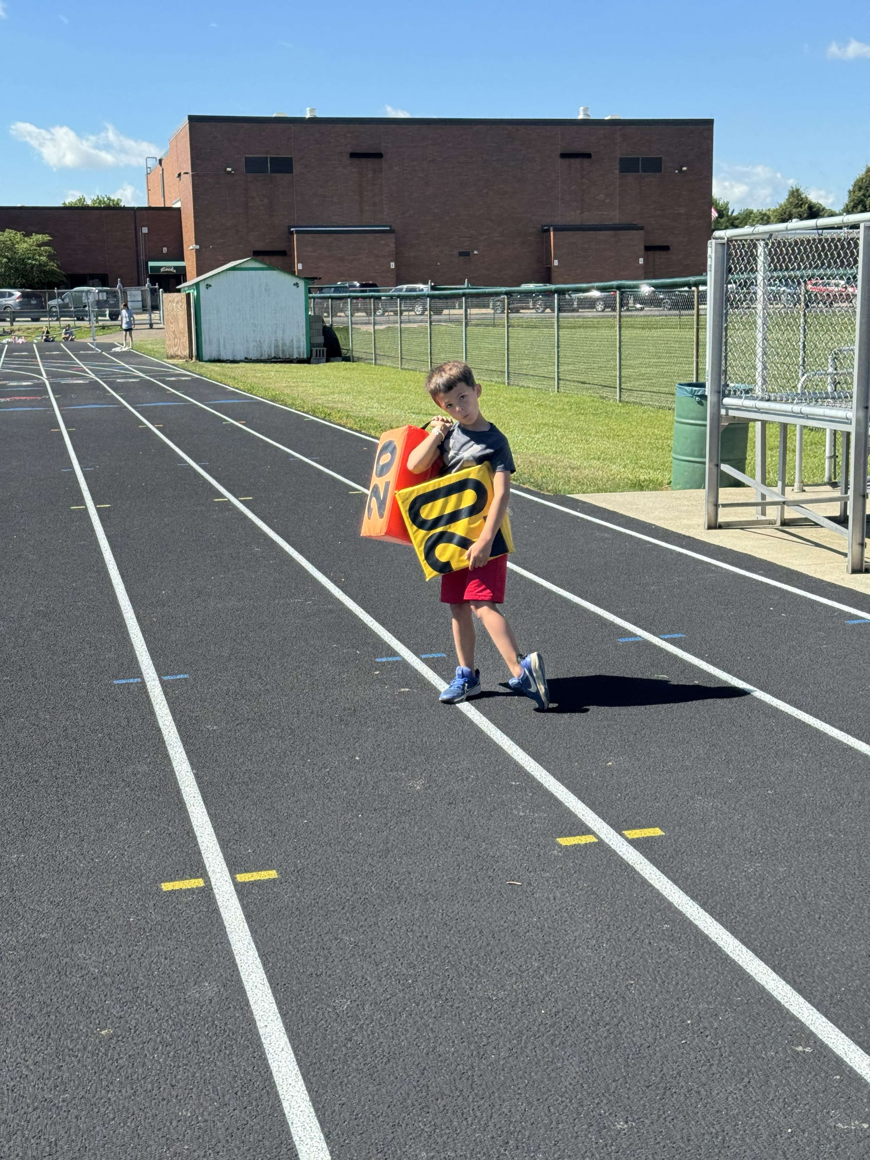 Young camper carrying lane markers on the Scioto track