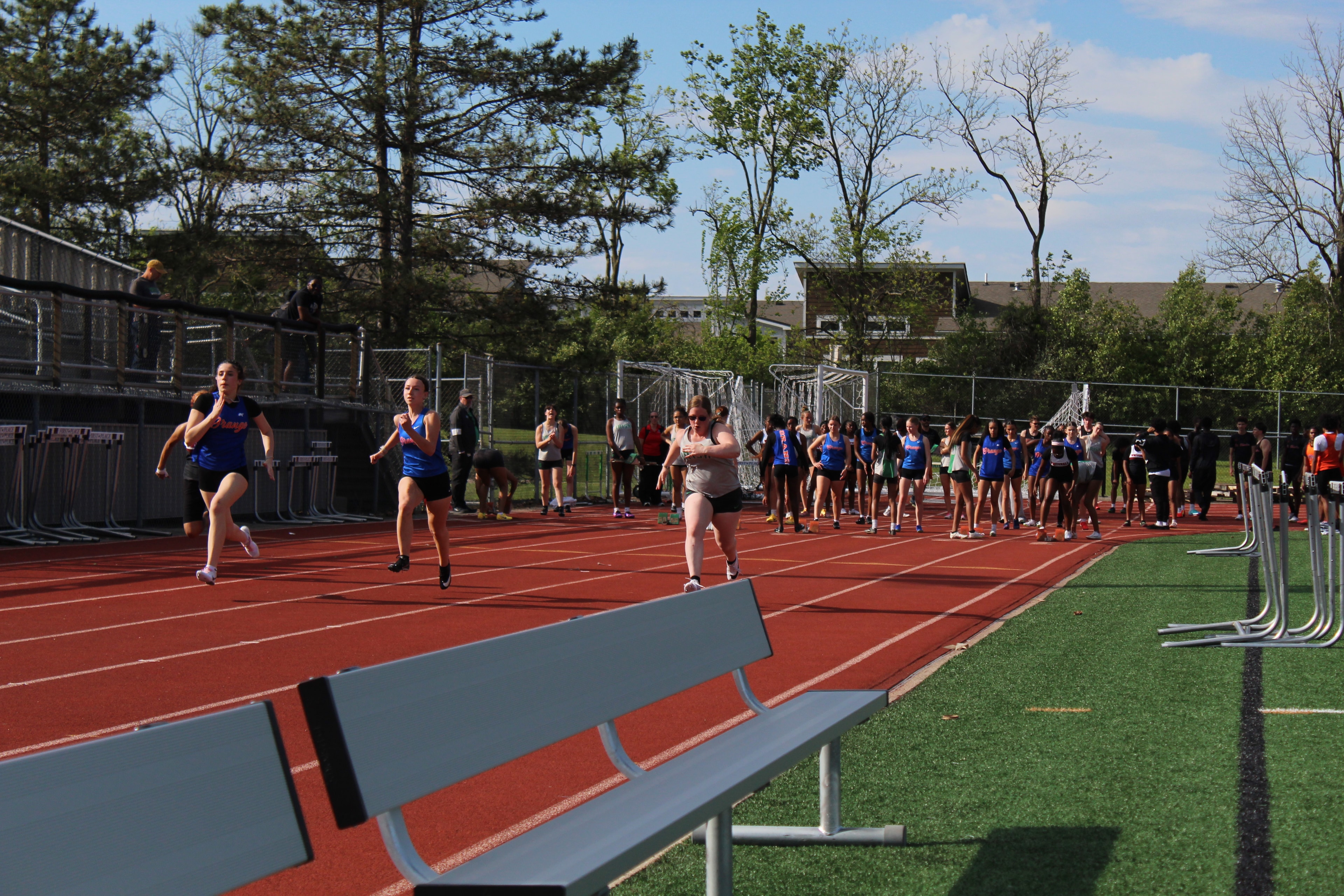 Girls sprinting down the track at a meet