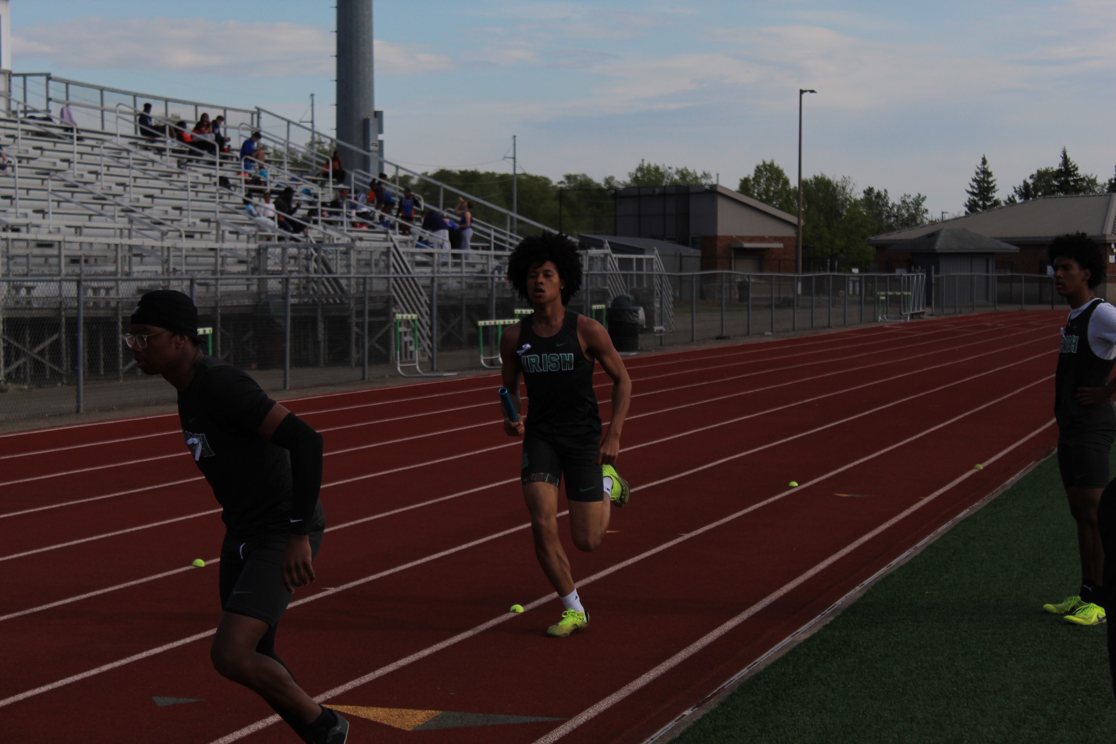 Irish relay runner carrying the baton on the track