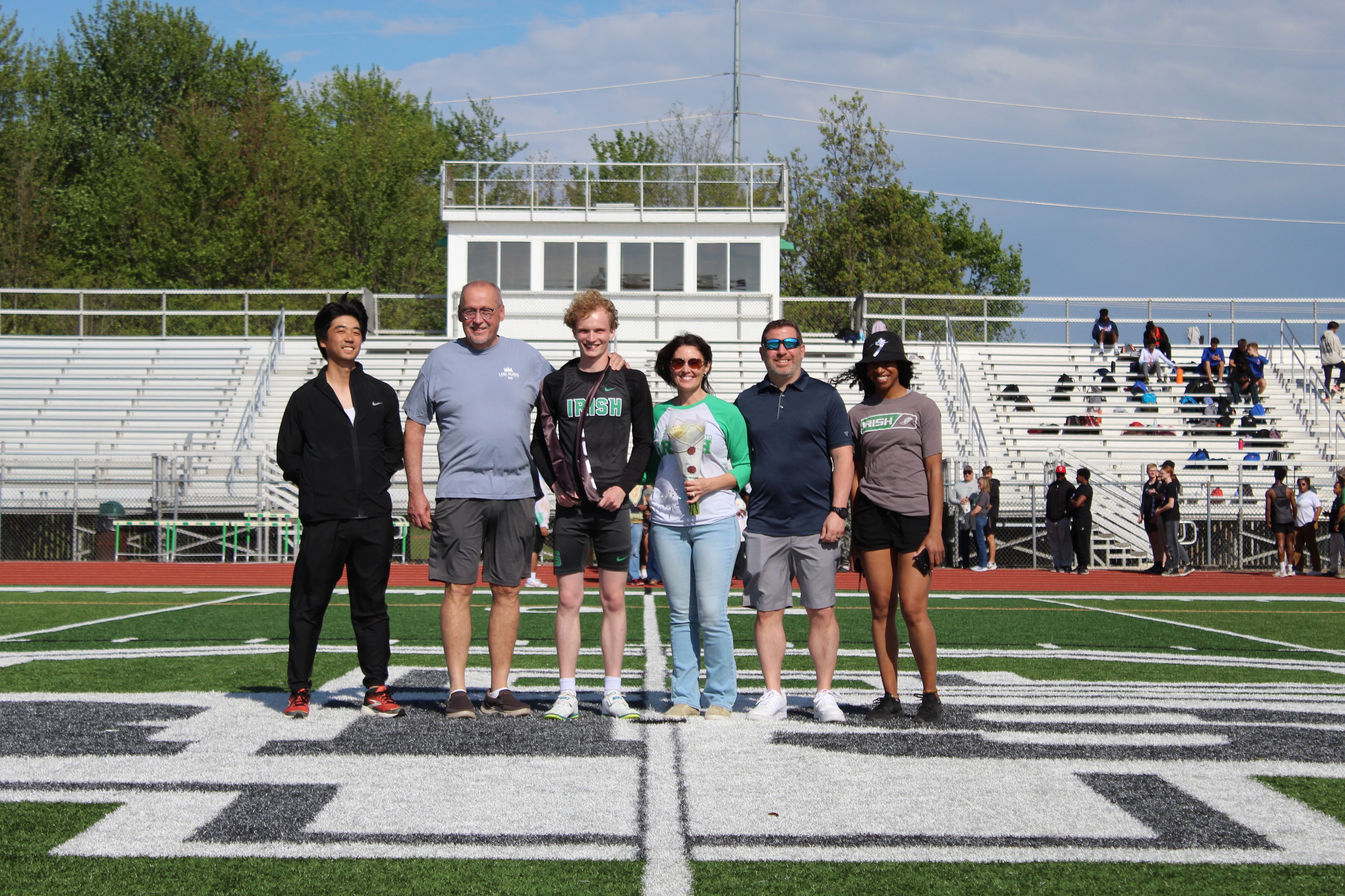 Senior and family on the field during Senior Night ceremony