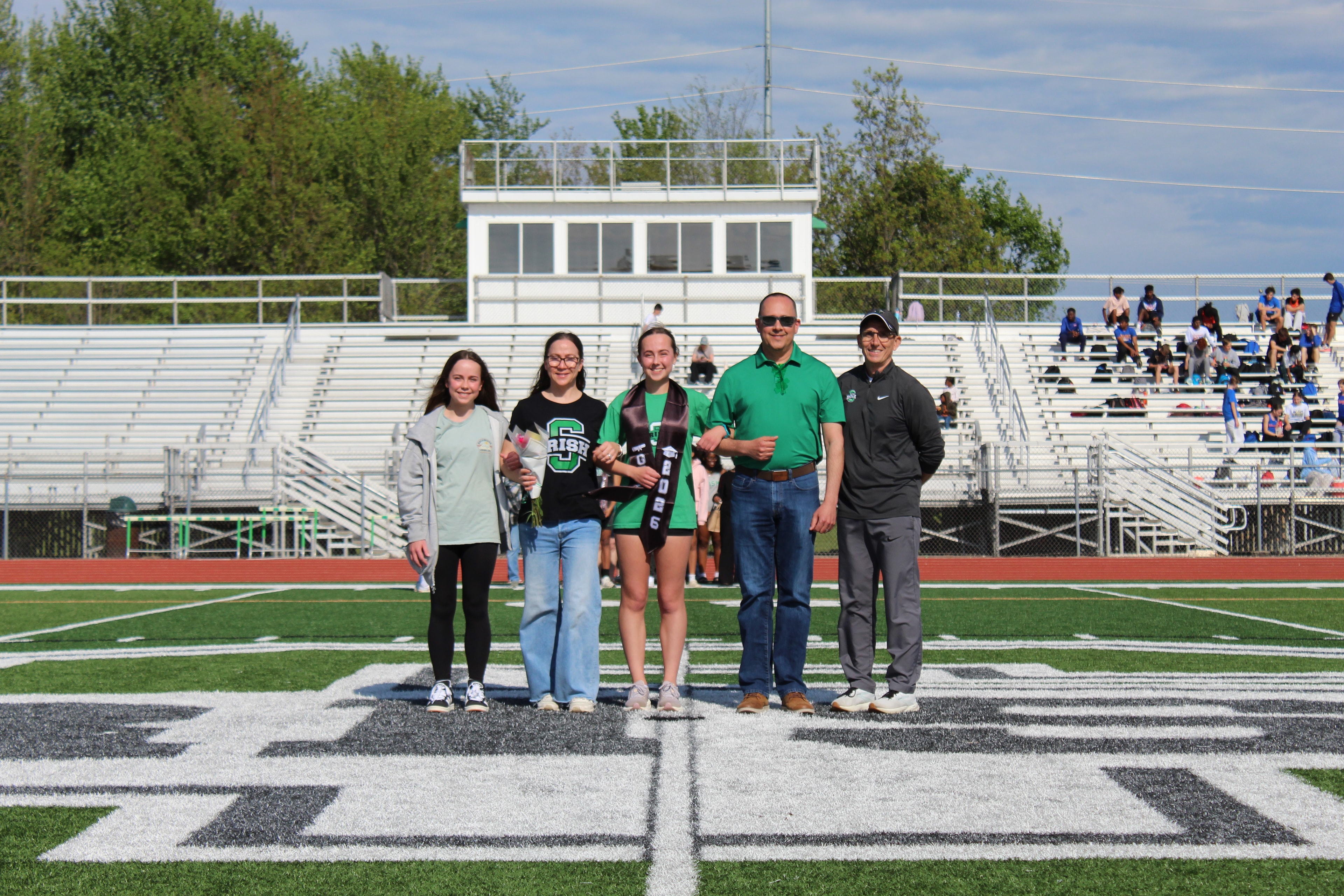 Senior in Irish jersey with graduation sash and large family group