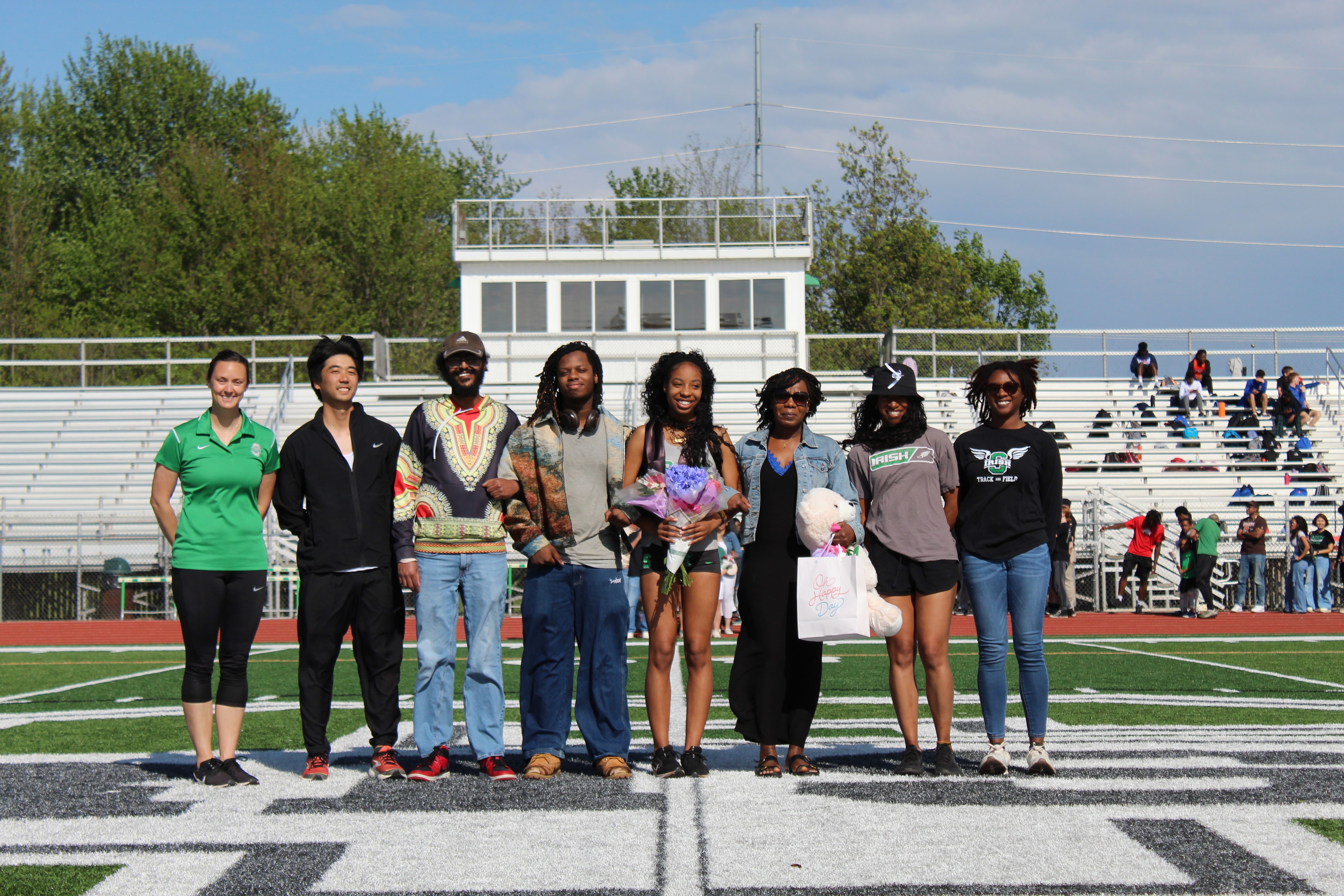 Senior and family with flowers on the field during Senior Night