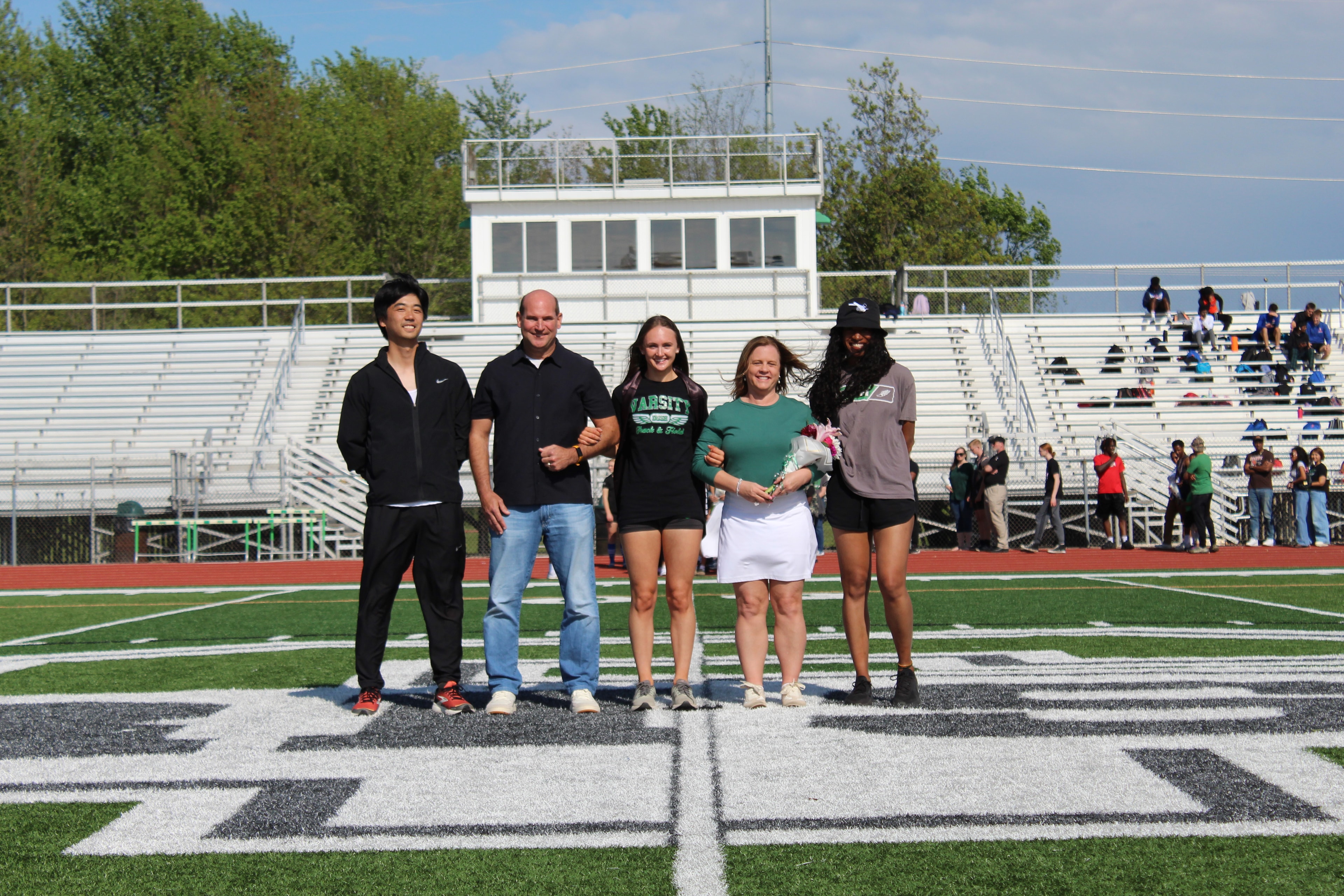 Senior athlete with family on the field during Senior Night