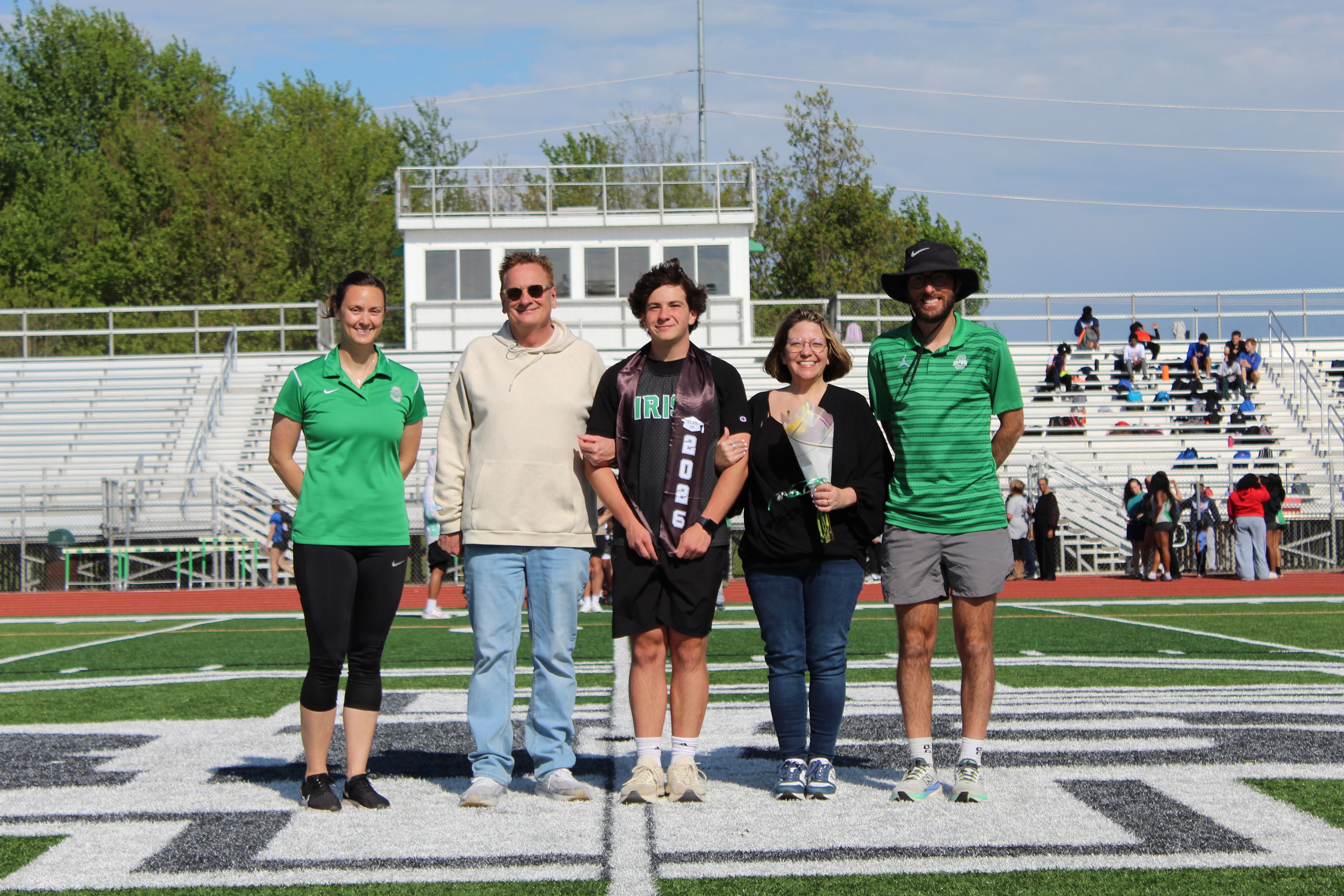 Senior in Irish jersey with graduation sash and family