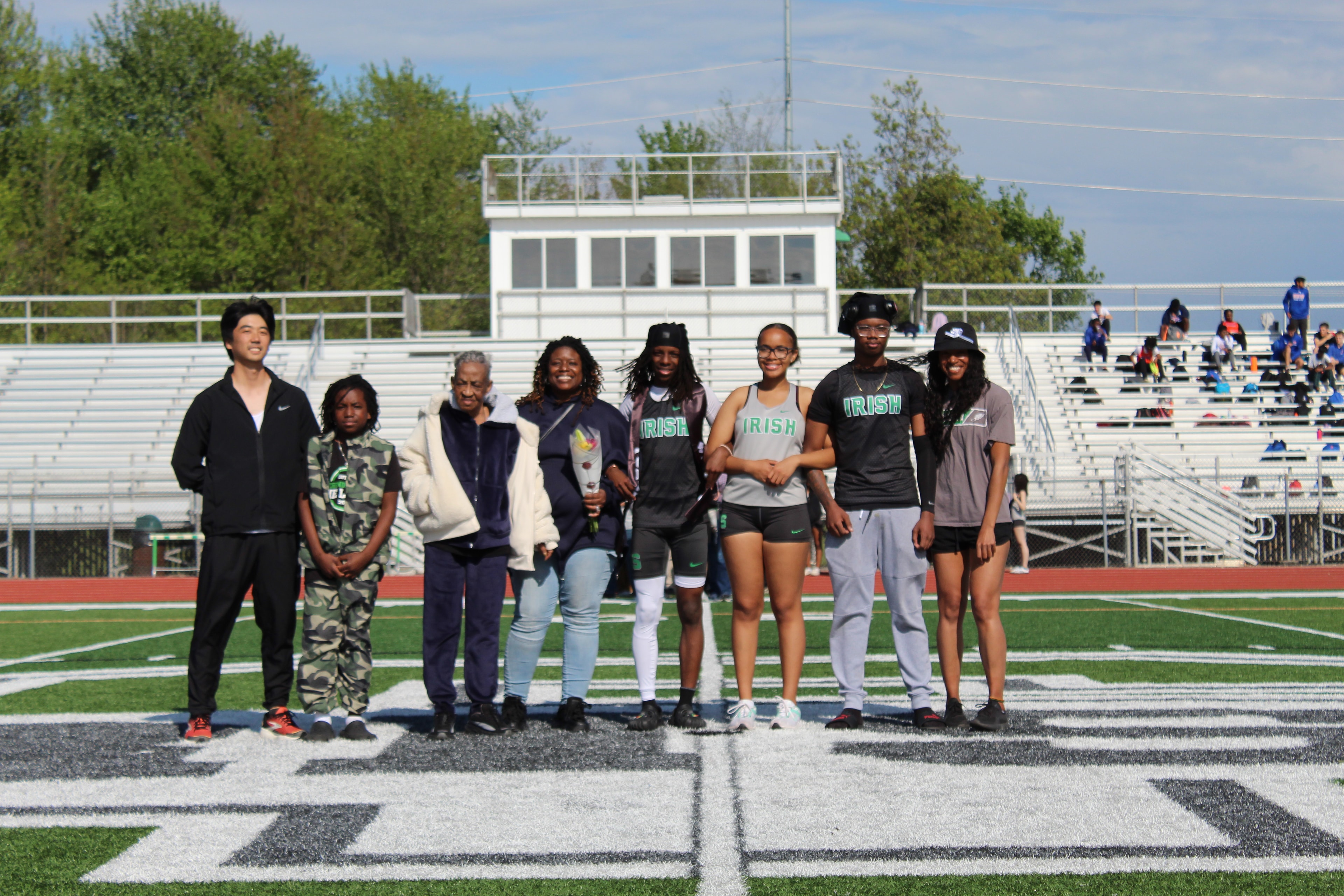 Senior with large family group on the field during Senior Night