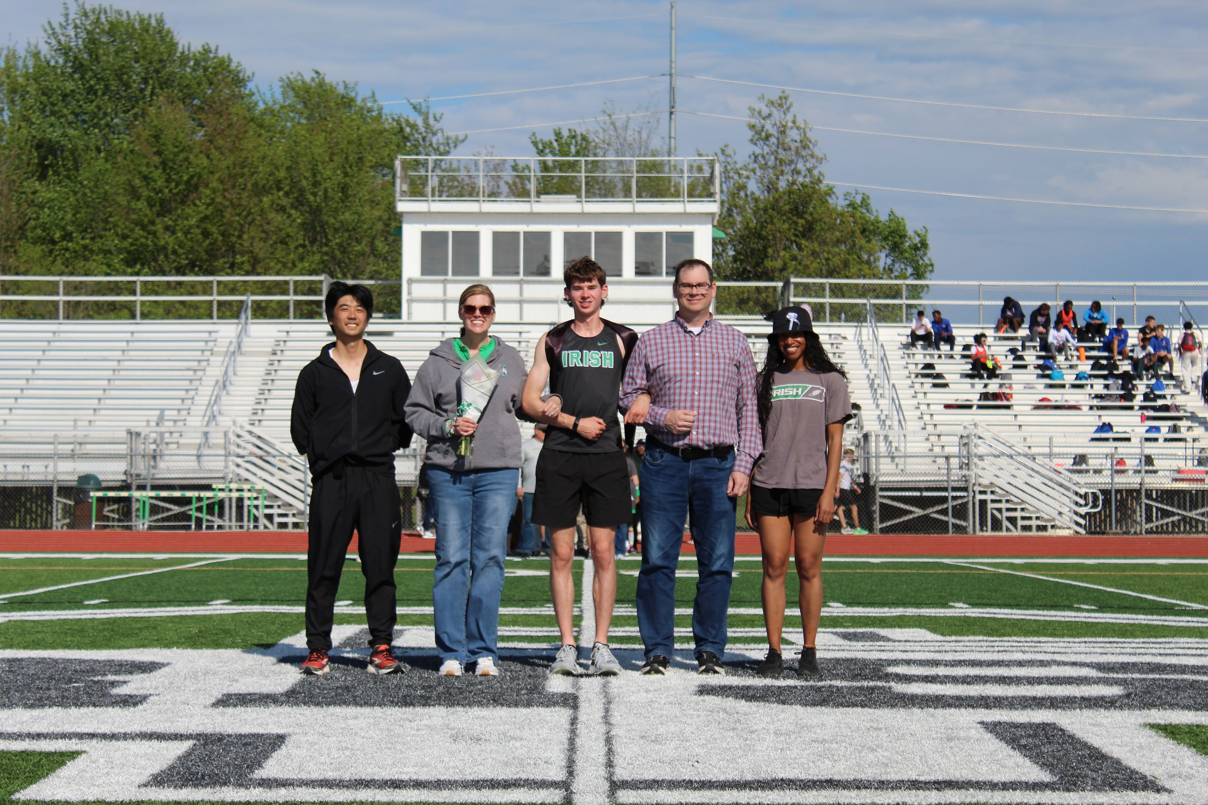 Senior in Irish jersey with family and teammates on the field