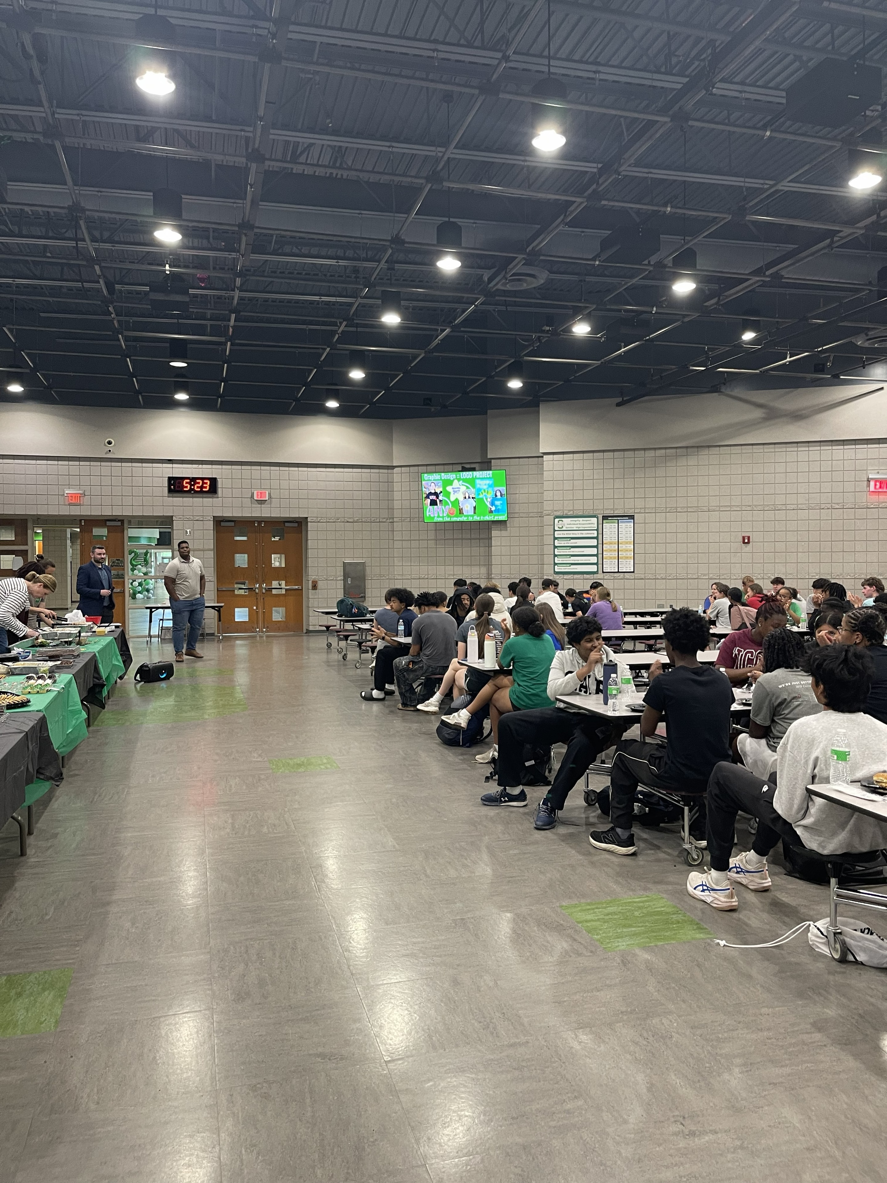 Athletes seated at tables enjoying the team meal
