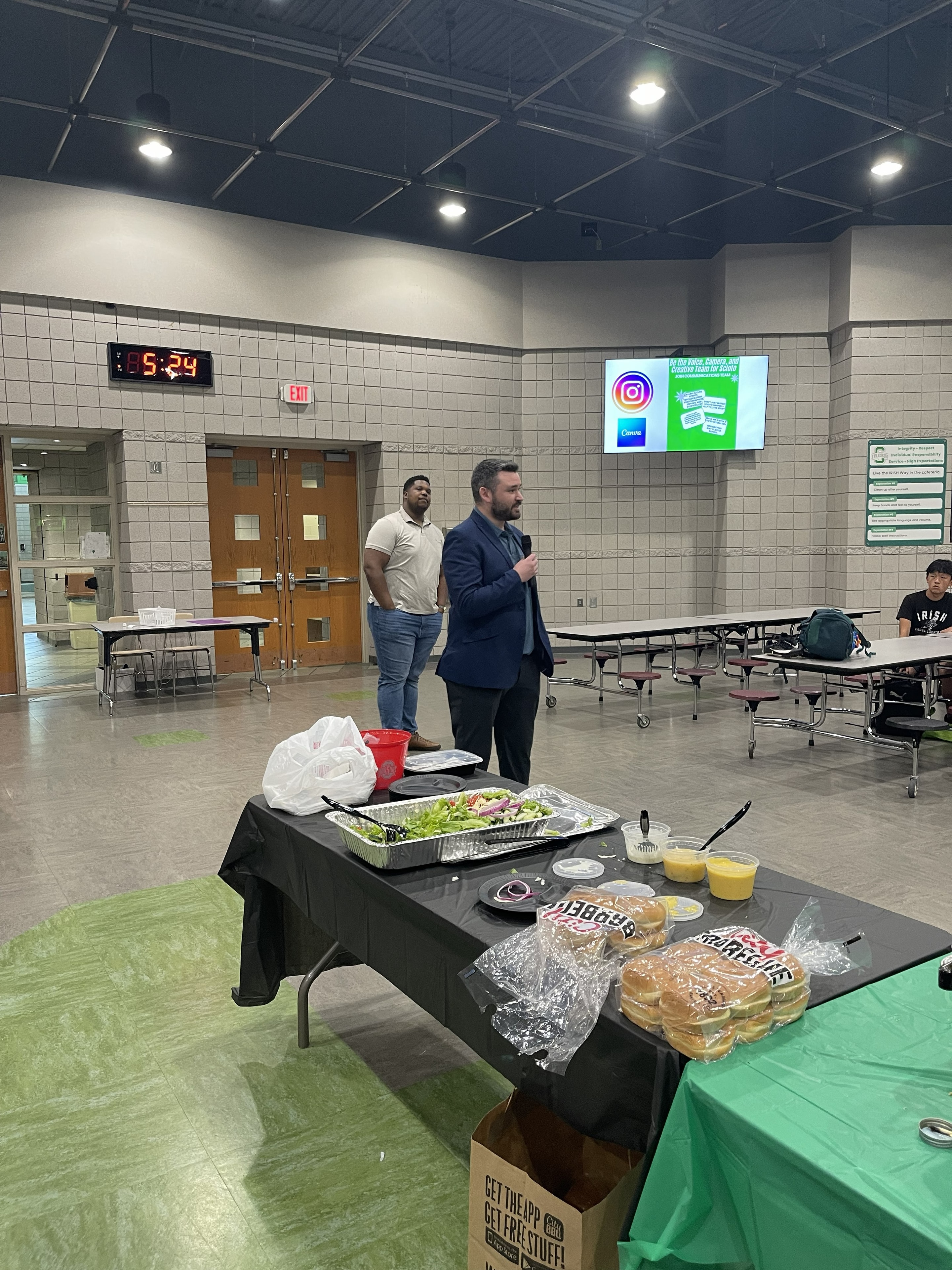 Coaches speaking to athletes at the team meal