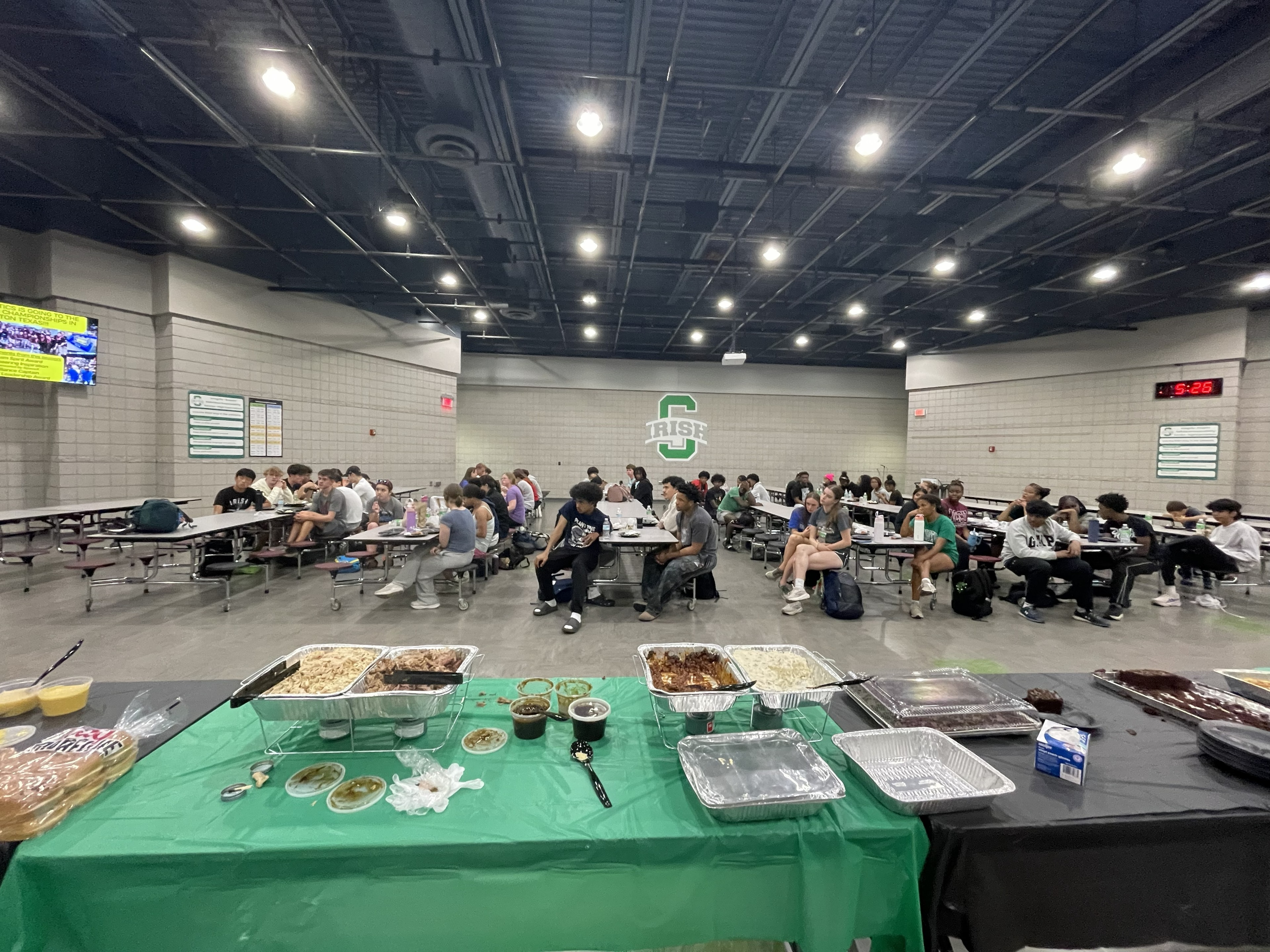 Team meal spread with food on green-covered tables