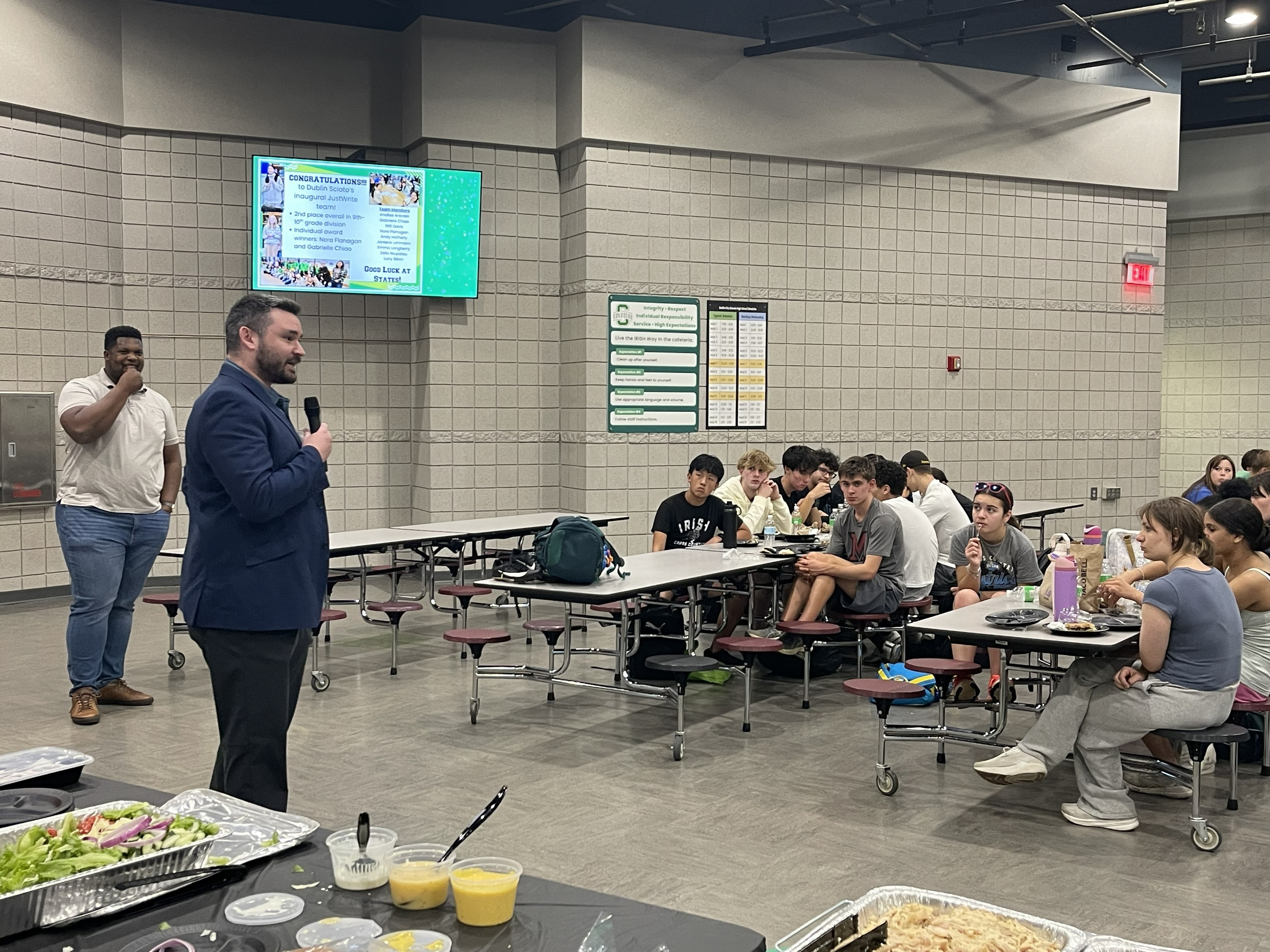 Coach addressing athletes at a team dinner
